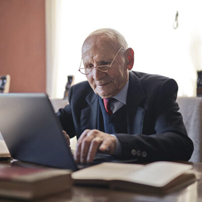Senior mit Laptop Senior arbeitet am Laptop
